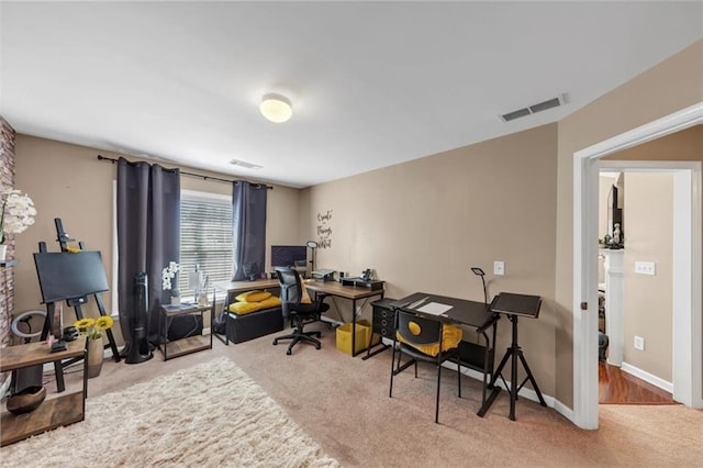 carpeted home office with visible vents and baseboards