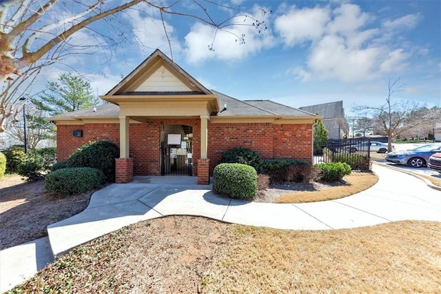 view of front of house with brick siding, fence, and a gate