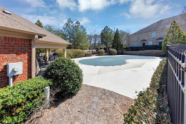 view of swimming pool featuring a patio, a fenced in pool, and fence