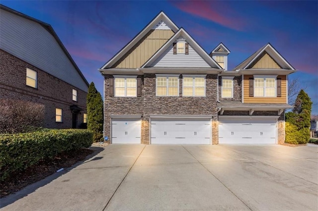 craftsman inspired home with stone siding, board and batten siding, concrete driveway, and a garage