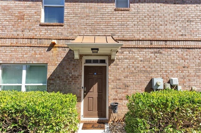 property entrance featuring brick siding and a standing seam roof