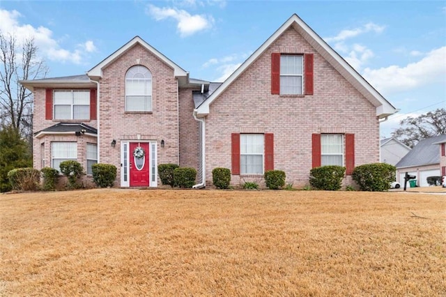 traditional-style house with brick siding and a front yard