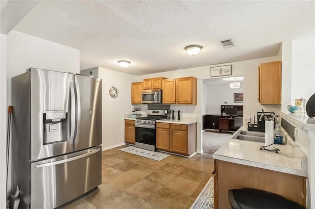 kitchen featuring a sink, light countertops, visible vents, and stainless steel appliances