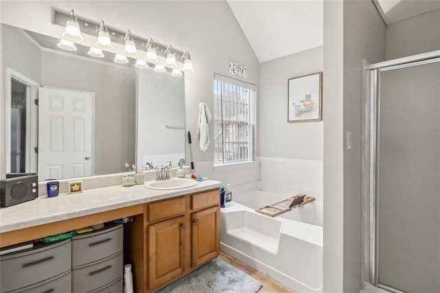 full bath featuring vanity, a garden tub, a stall shower, and vaulted ceiling