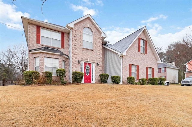 traditional home with brick siding and a front yard