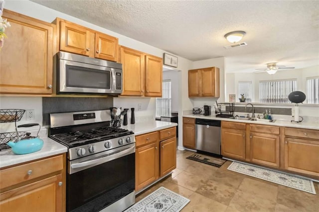 kitchen with visible vents, stainless steel appliances, light countertops, and a sink