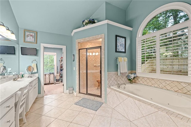 full bathroom with tile patterned flooring, a stall shower, vanity, vaulted ceiling, and a tub with jets
