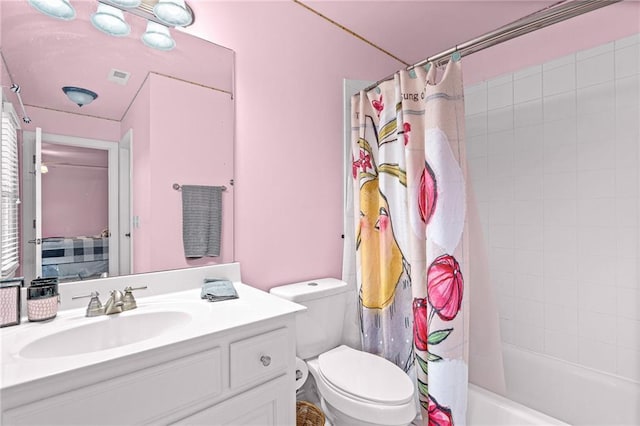 bathroom featuring toilet, vanity, and shower / bath combo with shower curtain