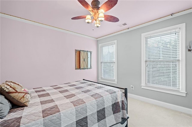 bedroom with ornamental molding, baseboards, light colored carpet, and ceiling fan