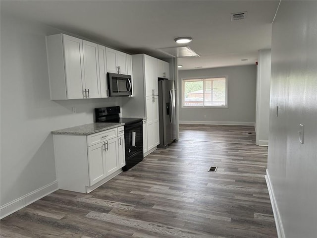 kitchen featuring light stone countertops, white cabinetry, dark hardwood / wood-style flooring, and stainless steel appliances