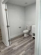 bathroom featuring toilet and wood-type flooring