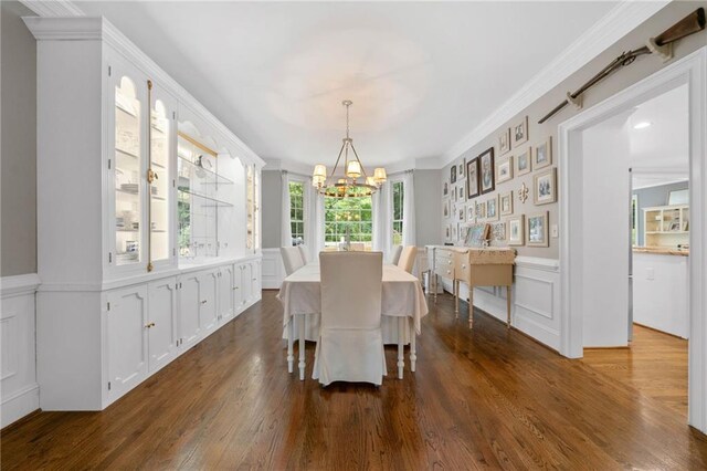 775 Barberry Dr, Milton, GA 30004 - dining space featuring a chandelier, a decorative wall, dark wood-style flooring, a wainscoted wall, and ornamental molding