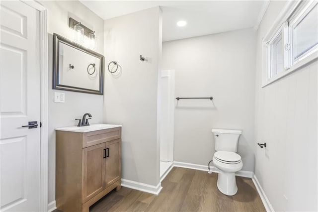 bathroom with a shower, toilet, vanity, and hardwood / wood-style flooring