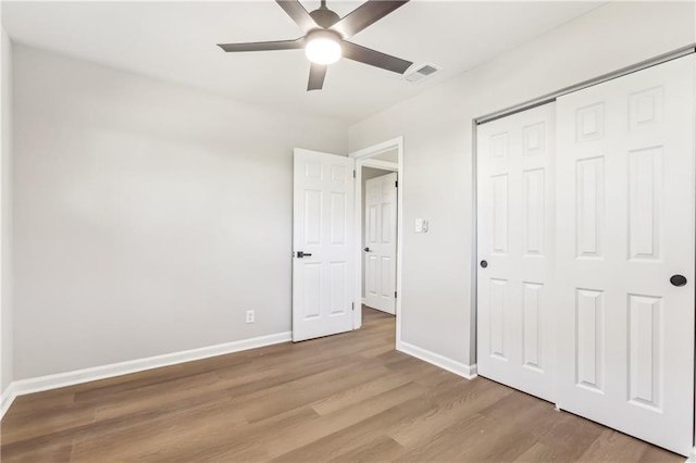 unfurnished bedroom featuring ceiling fan, light hardwood / wood-style flooring, and a closet