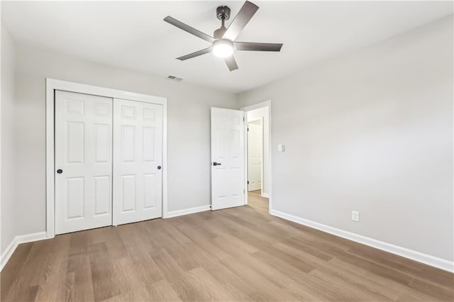 unfurnished bedroom with ceiling fan, light hardwood / wood-style flooring, and a closet