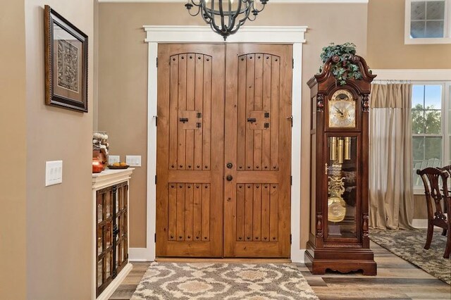 entryway with wood-type flooring and a chandelier