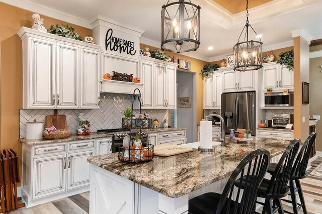 kitchen featuring an island with sink, light wood-type flooring, and appliances with stainless steel finishes