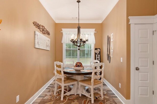 dining room featuring ornamental molding, an inviting chandelier, and hardwood / wood-style flooring