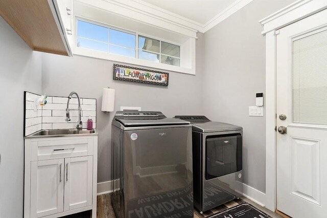 laundry room featuring cabinets, dark hardwood / wood-style floors, sink, independent washer and dryer, and crown molding