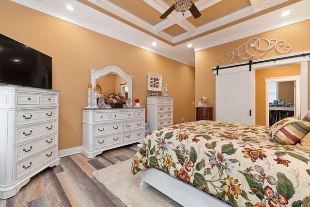 bedroom featuring ceiling fan, coffered ceiling, crown molding, a barn door, and dark hardwood / wood-style flooring