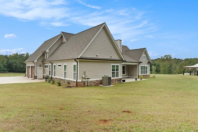 back of house featuring cooling unit and a yard