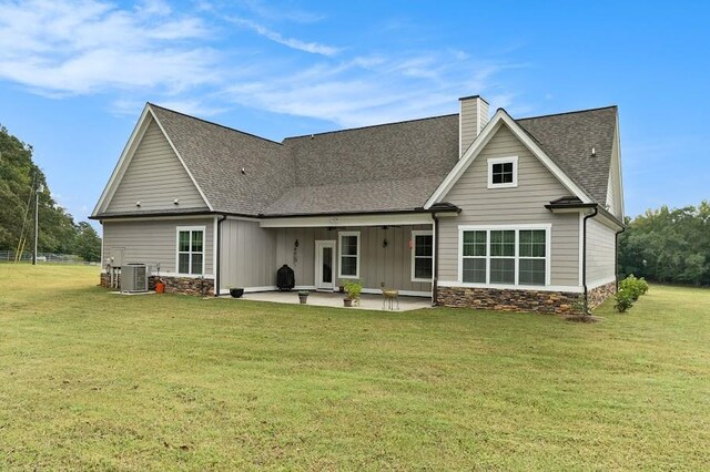 rear view of property featuring a patio, cooling unit, and a yard