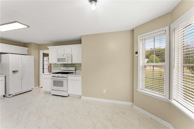 kitchen with white appliances, baseboards, marble finish floor, and light countertops