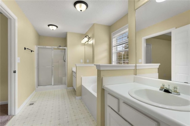 bathroom with a garden tub, a stall shower, vanity, baseboards, and tile patterned floors