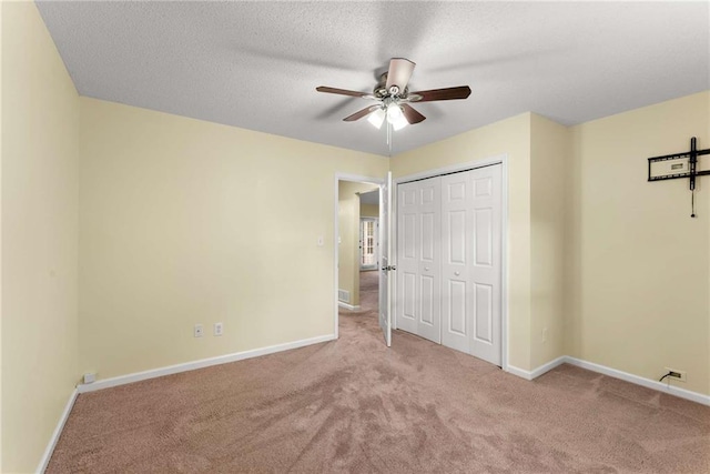 unfurnished bedroom featuring a textured ceiling, carpet floors, a closet, and baseboards