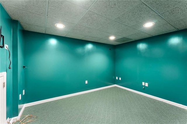 below grade area featuring a paneled ceiling, carpet, baseboards, and recessed lighting