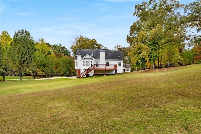 rear view of property featuring a yard, stairway, and a wooden deck