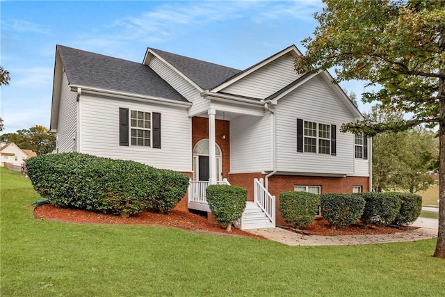 raised ranch with brick siding, a front yard, and a shingled roof