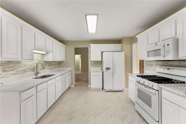 kitchen featuring marble finish floor, white appliances, a sink, and white cabinetry