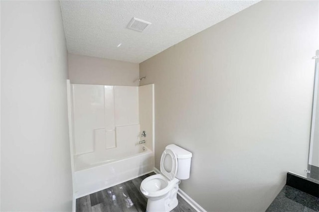 212 Cobb St, Cedartown, GA 30125 - full bath featuring visible vents, wood finished floors, toilet, bathtub / shower combination, and a textured ceiling