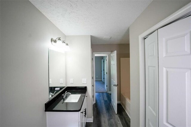 212 Cobb St, Cedartown, GA 30125 - bathroom with a bathtub, a textured ceiling, wood finished floors, vanity, and baseboards