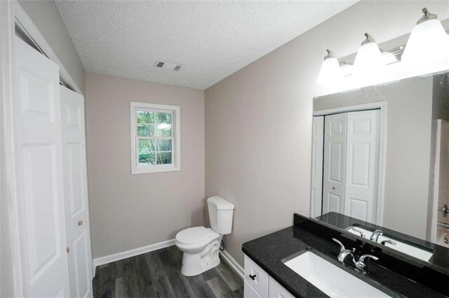 212 Cobb St, Cedartown, GA 30125 - bathroom featuring visible vents, a closet, vanity, wood finished floors, and toilet
