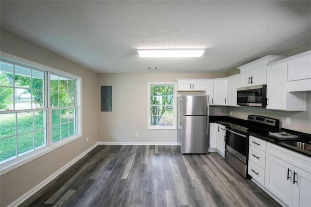 212 Cobb St, Cedartown, GA 30125 - kitchen featuring dark countertops, dark wood-type flooring, a textured ceiling, white cabinets, and stainless steel appliances