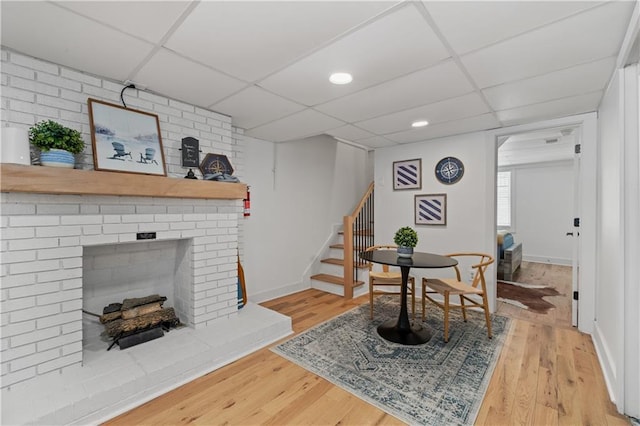 6160 Lake Lanier Heights Rd, Buford, GA 30518 - living room featuring a paneled ceiling, stairs, light wood-type flooring, and a brick fireplace