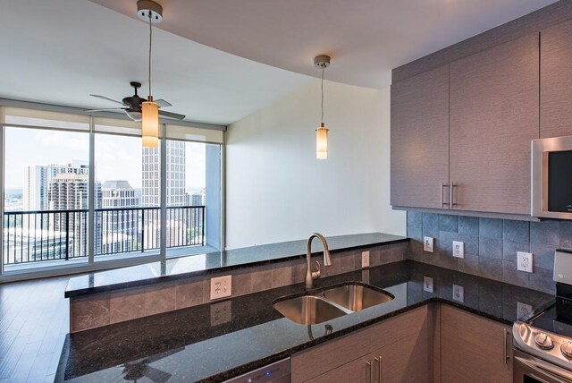 kitchen featuring ceiling fan, a wealth of natural light, sink, decorative light fixtures, and stainless steel dishwasher