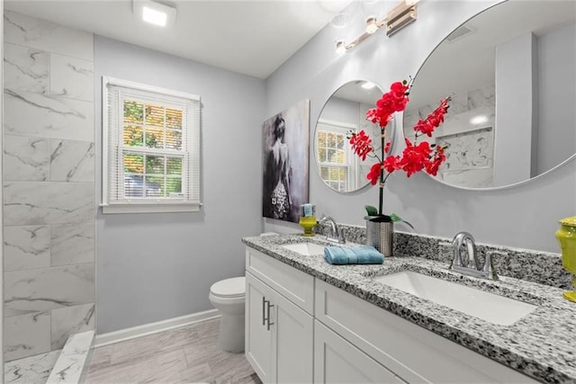 1245 Meriwether St, Griffin, GA 30224 - full bathroom with double vanity, marble finish flooring, toilet, baseboards, and a marble finish shower