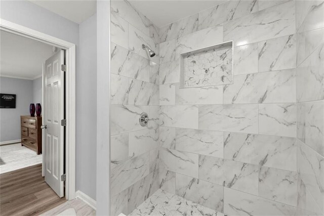 1245 Meriwether St, Griffin, GA 30224 - bathroom with tiled shower, wood finished floors, baseboards, and ornamental molding