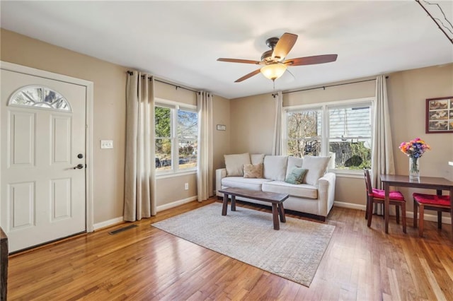 living room featuring wood-type flooring and ceiling fan