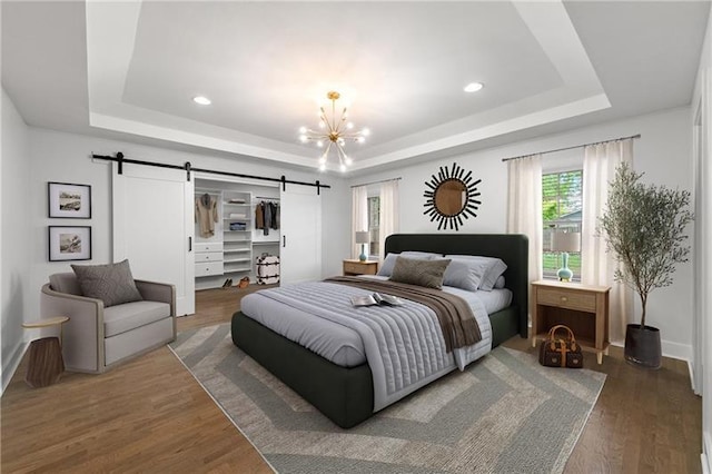 957 Sharon Cir SE, Smyrna, GA 30080 - bedroom with a barn door, a raised ceiling, a chandelier, wood finished floors, and recessed lighting
