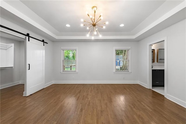 957 Sharon Cir SE, Smyrna, GA 30080 - unfurnished bedroom with a chandelier, wood finished floors, a tray ceiling, a barn door, and recessed lighting