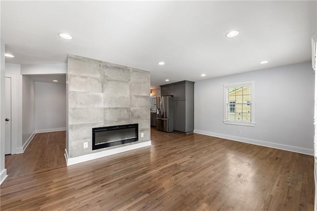 957 Sharon Cir SE, Smyrna, GA 30080 - unfurnished living room featuring baseboards, a fireplace, wood finished floors, and recessed lighting