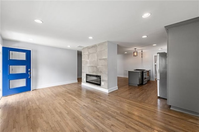 957 Sharon Cir SE, Smyrna, GA 30080 - unfurnished living room featuring baseboards, recessed lighting, a tiled fireplace, and wood finished floors
