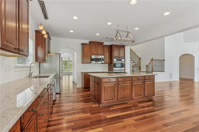 4540 Hastings Dr, Cumming, GA 30041 - kitchen with arched walkways, stainless steel appliances, a sink, dark wood-style floors, and recessed lighting