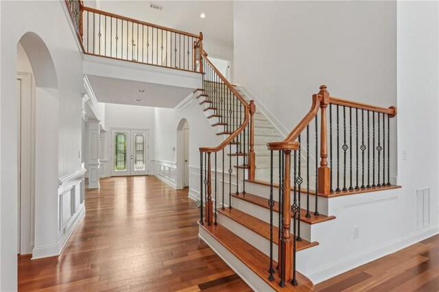 4540 Hastings Dr, Cumming, GA 30041 - stairs with arched walkways, wood finished floors, a high ceiling, and a decorative wall
