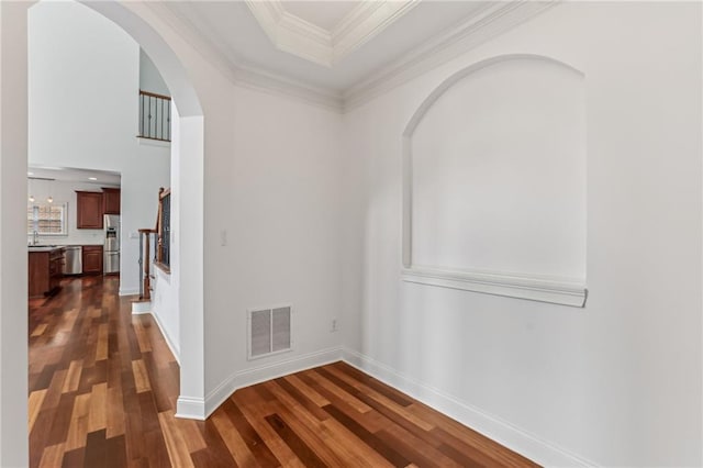 4540 Hastings Dr, Cumming, GA 30041 - hallway with arched walkways, dark wood finished floors, a sink, stairway, and ornamental molding