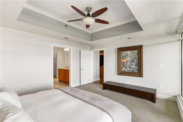 bedroom with connected bathroom, crown molding, baseboards, light colored carpet, and a raised ceiling